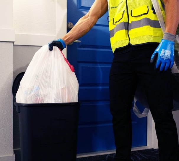 Valet trash service taking out the trash from in front of a resident's door.