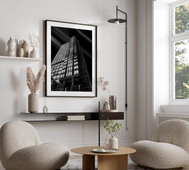 a living room with a couch and chairs and black and white architecture  hanging on the wall
