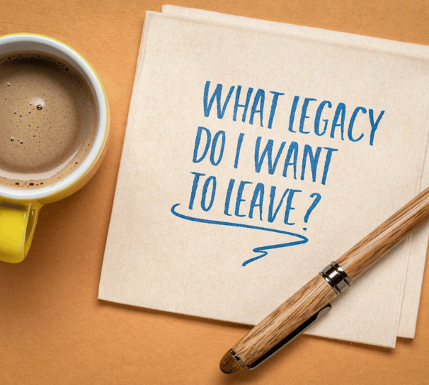 Notebook with message ‘What legacy do I want to leave?’ and coffee cup, symbolizing estate planning.