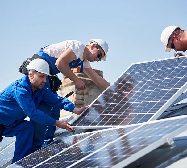 Un groupe de Techniciens entrain d'installer des panneaux solaire sur un toit