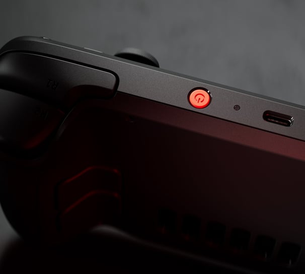 "Close-up of the Steam Deck OLED with a red power button, highlighting the sleek design and premium