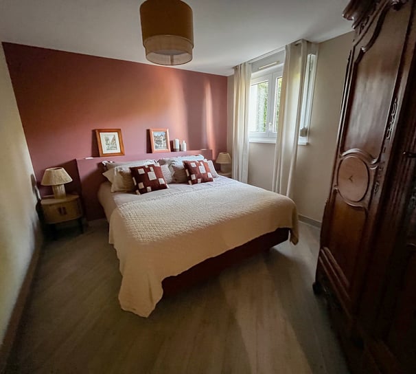 a bedroom with a bed and a wooden cabinet
