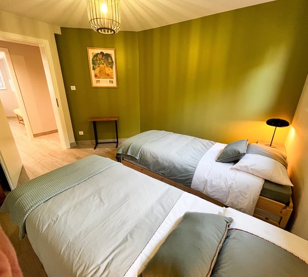 a bedroom with two beds and a lamp