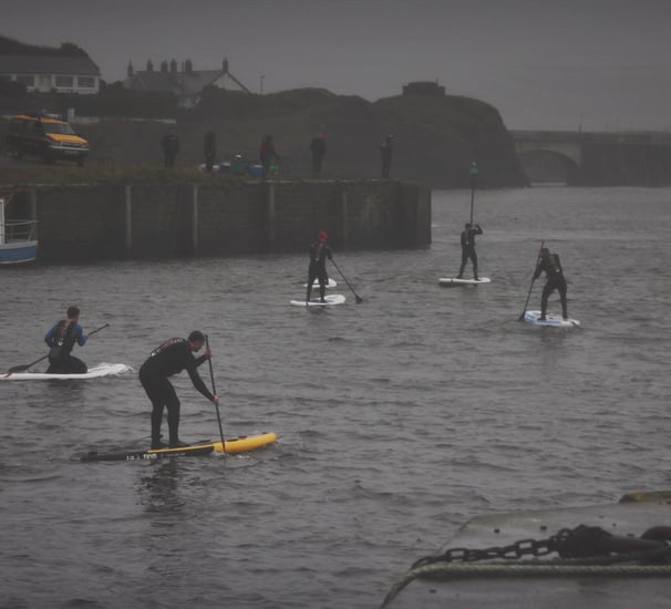 A paddle board race in Aberystwyth harbour on a grey December day