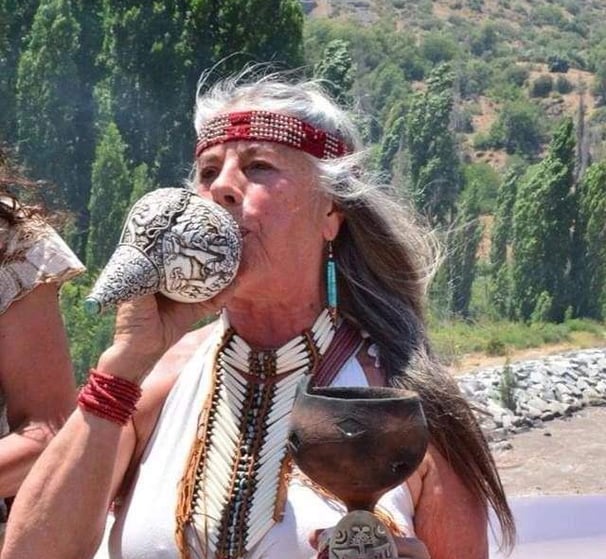 Mujer tocando un cuerno ceremonial