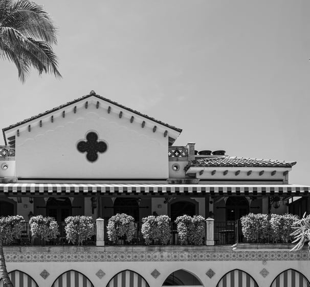 black and white shot of the del mar hotel with a tall palm tree on 5th avenue naples florida