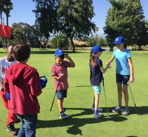 Enhancing Forward Action Inc. image of a group children on a golf course shacking hands