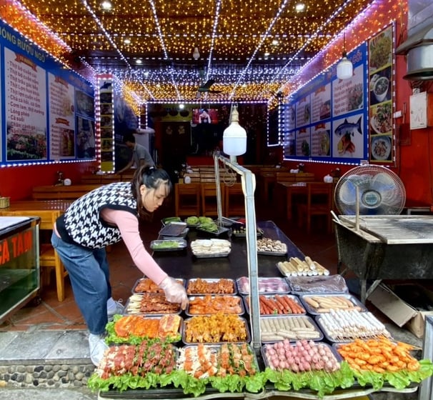 a woman is standing in front of a display of food