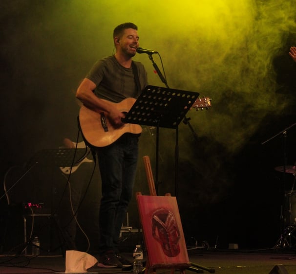a man singing playing guitar and leading worship