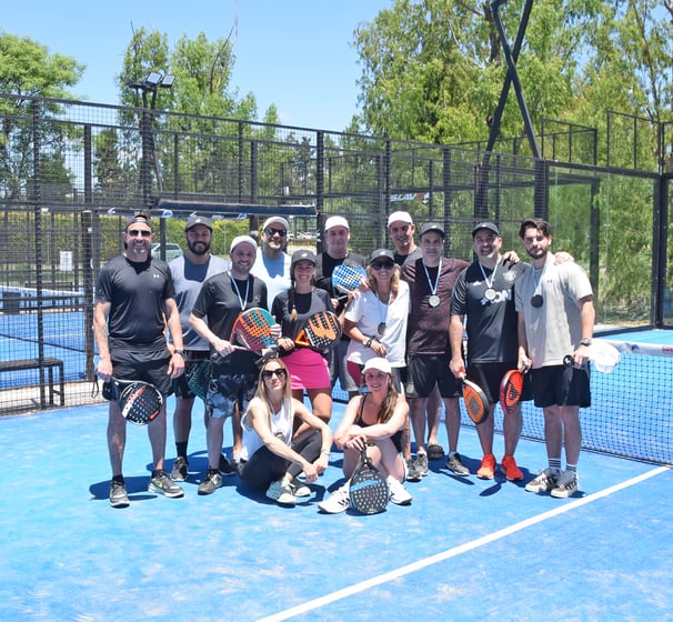 grupo de personas posando en una cancha de padel