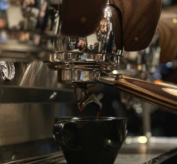 a cup of coffee being poured into a cup