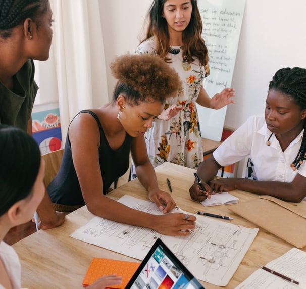 Diverse business women around a table scaling their business