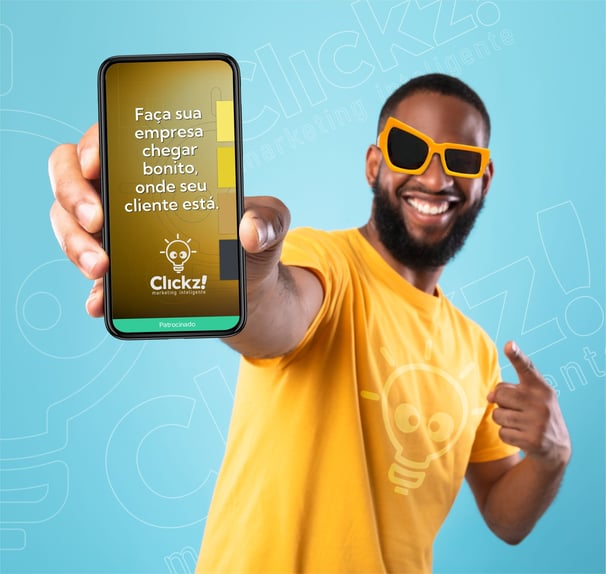 Homem de óculos escuro sorrindo segurando celular informando sobre serviço de trafégo pago.