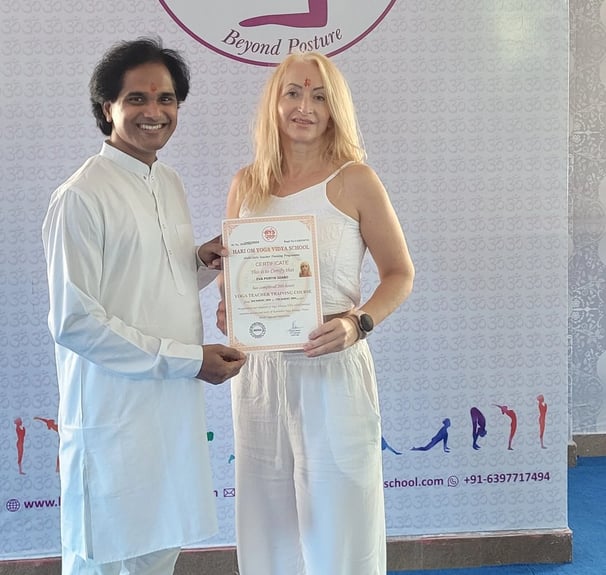 Eva receiving her yoga teacher certificate after completing training