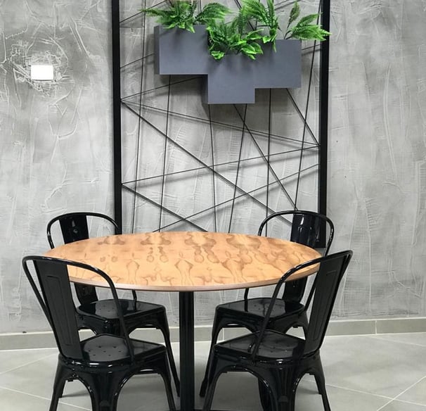 a table with chairs and a planter with plants