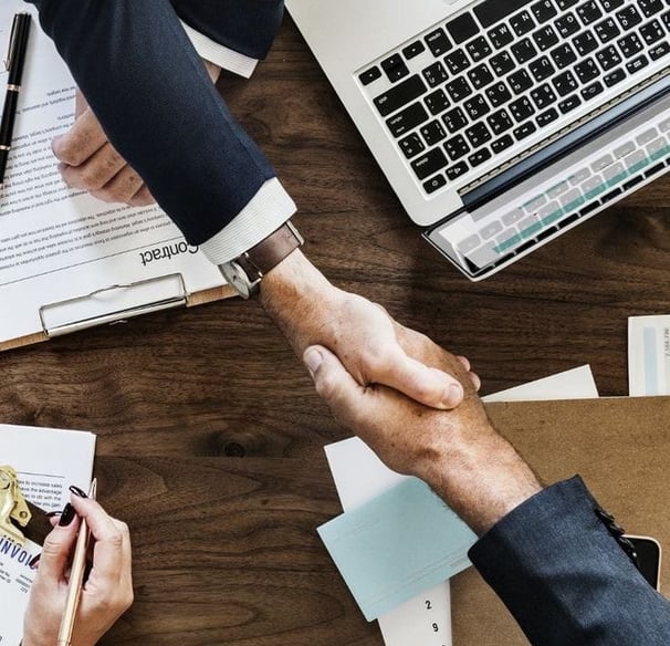 a group of people shaking hands over a desk