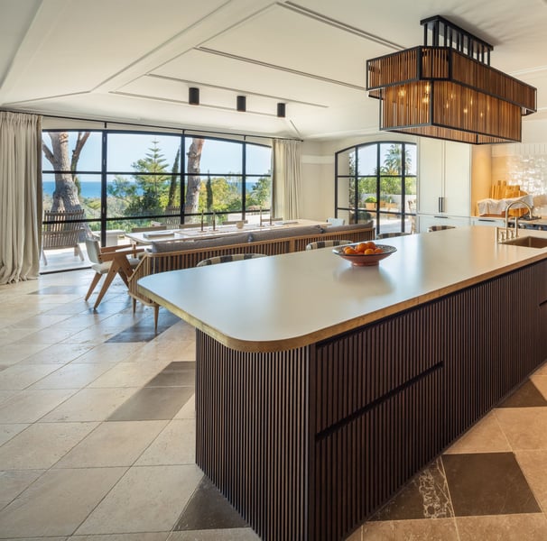 Contemporary kitchen at Villa La Gratitud with central island, designer lighting, and sea views.