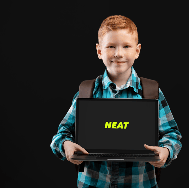 a boy holding a laptop computer with a sign that says neat