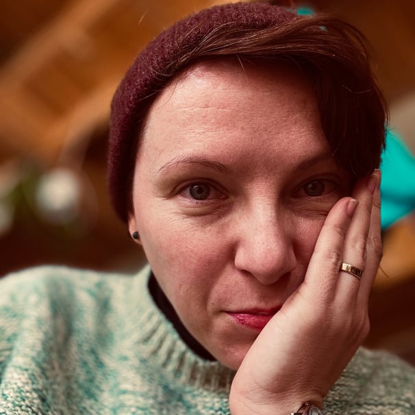 a woman with a red hat and a green sweater