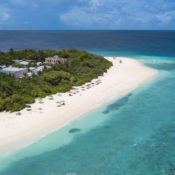 a beach with a white sand and blue sky