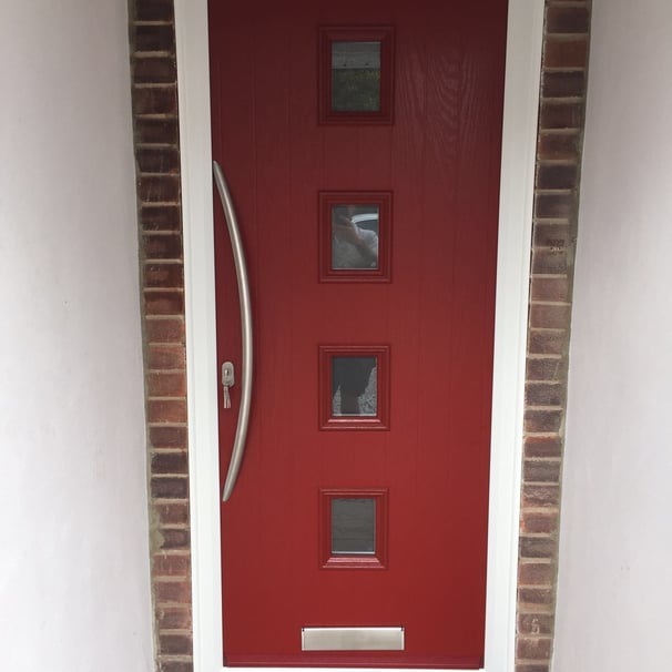a new red composite front door with 4 squares of glass and curved long handle