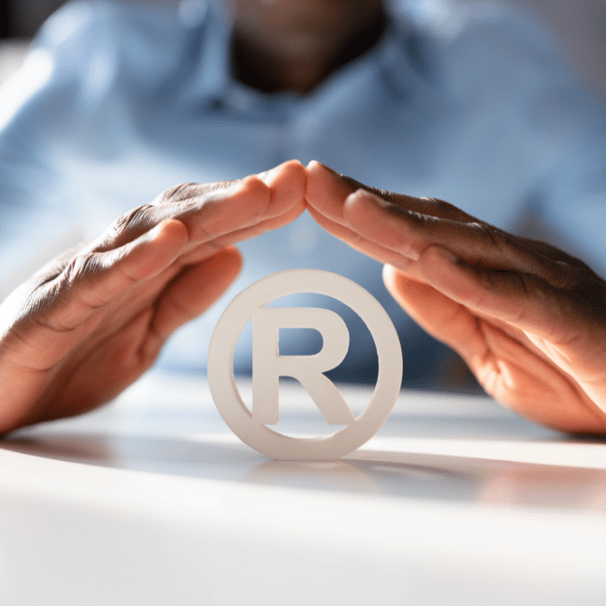 a person holding a paper cutout of a symbol of a registered trademark trademark trademark