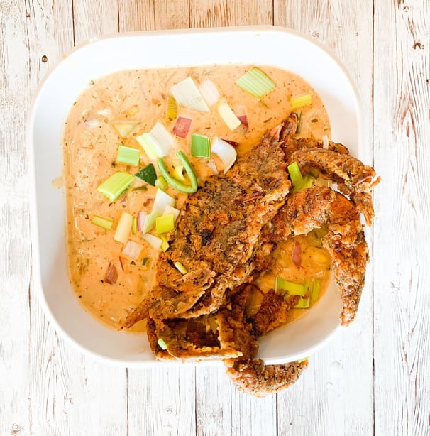 a bowl of soup with a fried crab