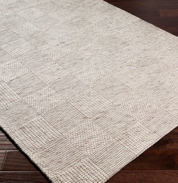 square printed neutral rug the rug is cream, linen, tan colored on dark hard wood floors