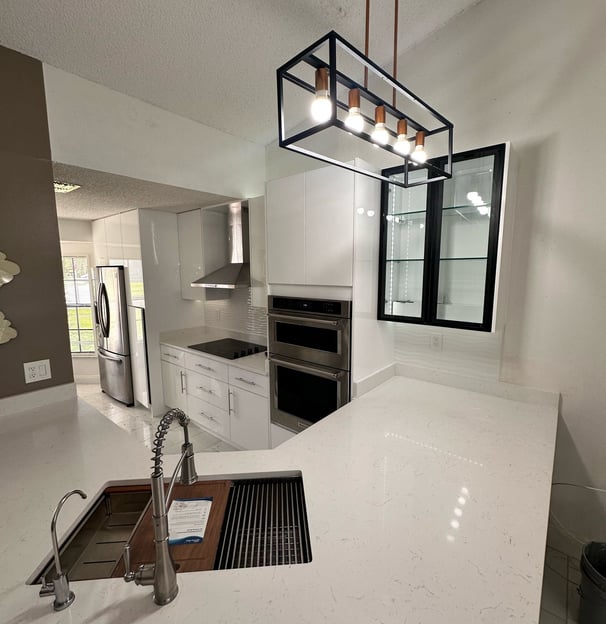 Kitchen remodel with wood accents, large prep island, and under-cabinet lighting by Central Florida