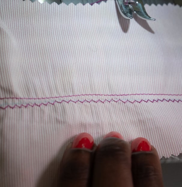 Straight stitch parallel to zig zag stitches shown on pink fabric