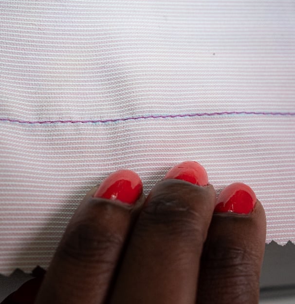Straight stitches shown on pink fabric