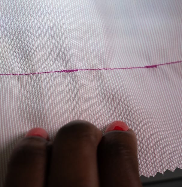 Backstitching shown on pink fabric