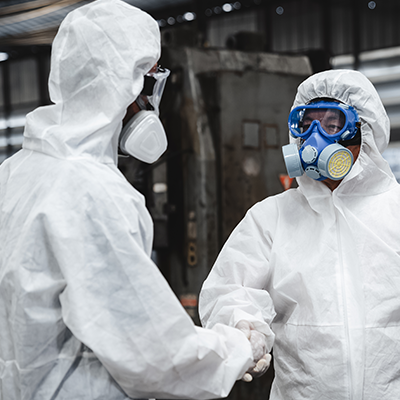 two people in white protective gear standing in a warehouse
