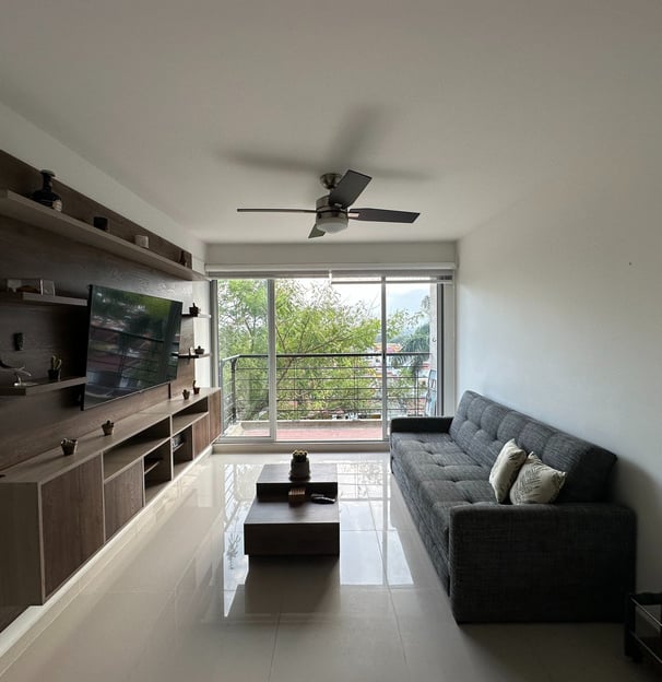 a living room with a couch and a ceiling fan