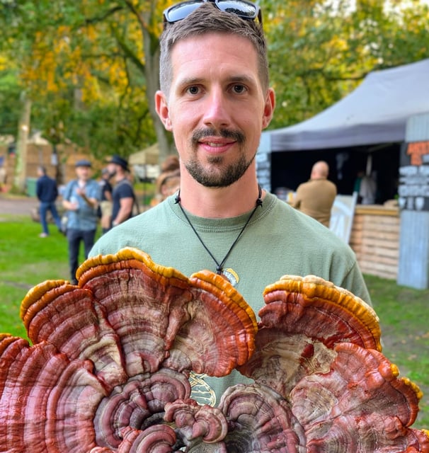 a man holding a large Reishi Mushroom - ganoderma lucidum, or Lingzhi