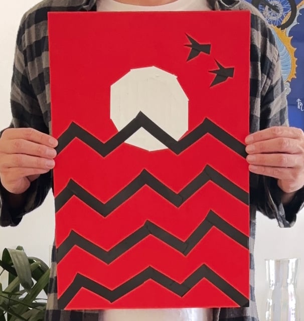 papel vermelho, onde um sol branco está desenhado com fitas, que também fazem o desenho de ondas pretas e duas aves no céu.