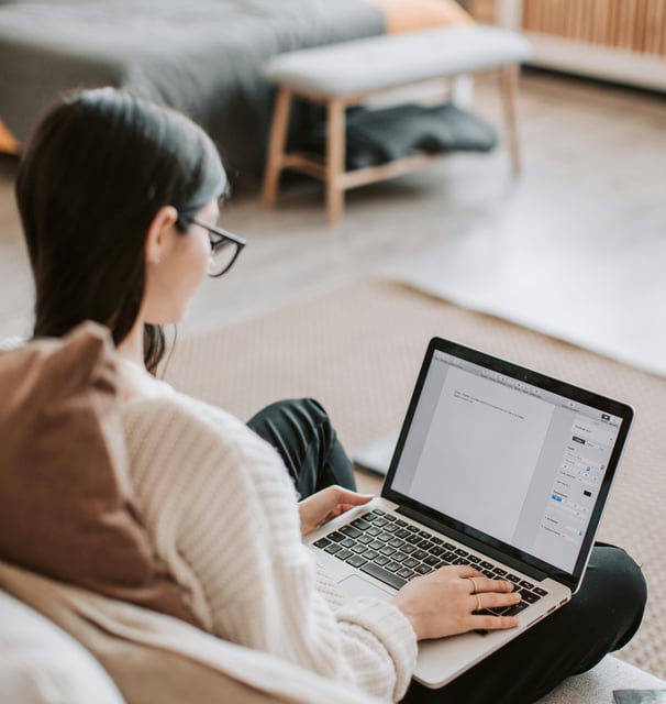 a woman sitting on a couch with a laptop