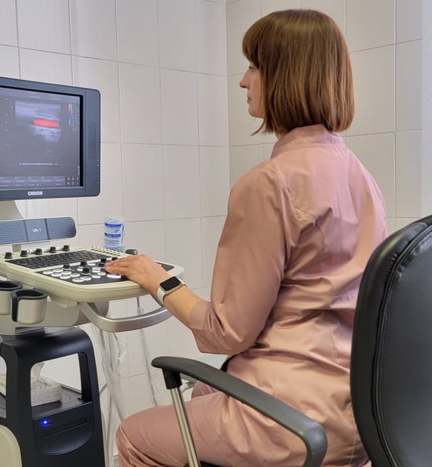 a woman in a pink shirt is sitting at a computer