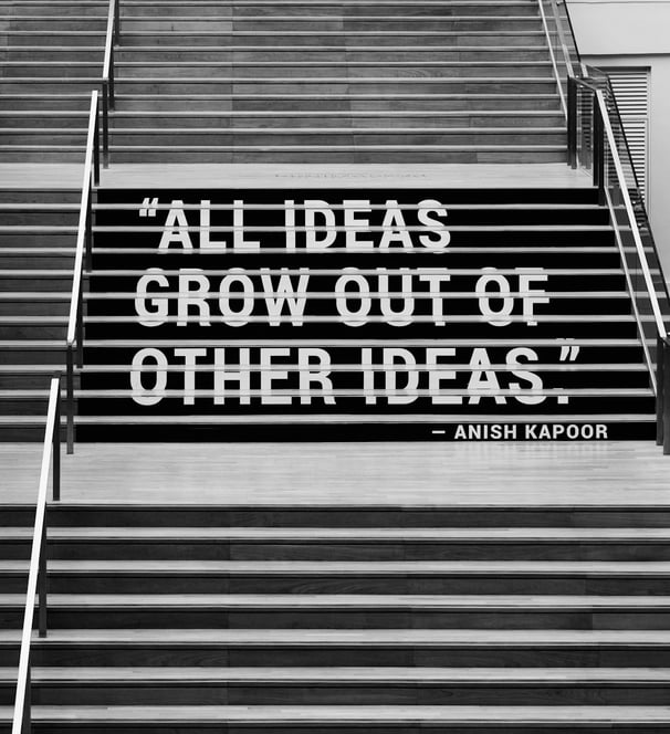 a woman walking down stairs with a quote about ideas