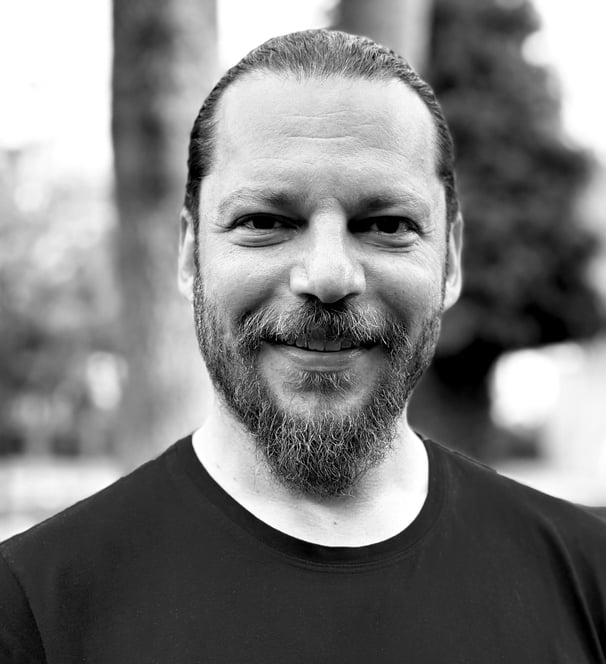 Alper Sümengen Tai Ji Qi Gong and sword instructor of WDP Turkey, smiling outdoors in black shirt