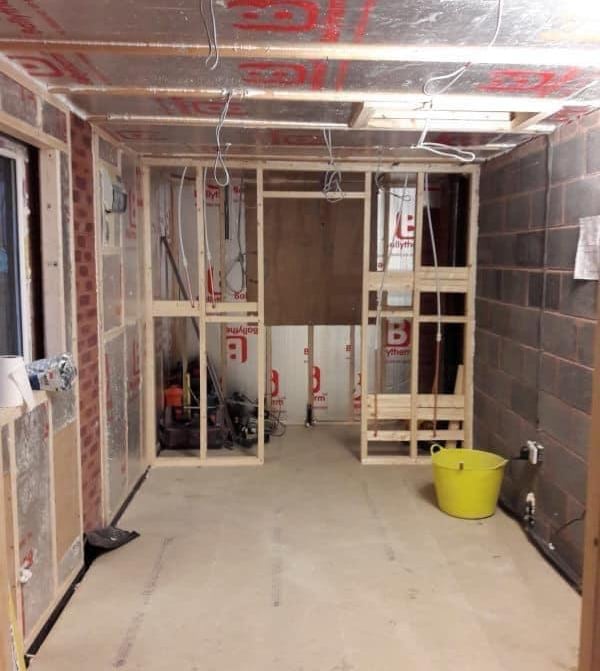 Garage conversion companies- stud wall with insulation and exposed brick
