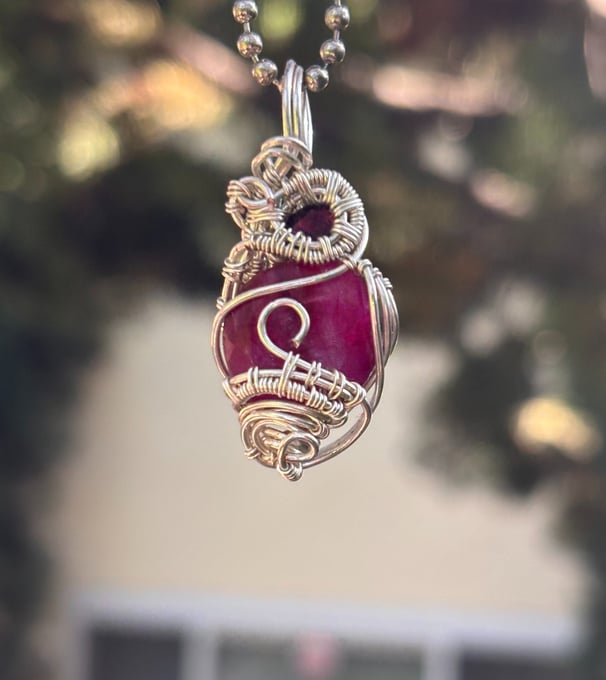 a necklace with a red and white pendant with a dragon on it