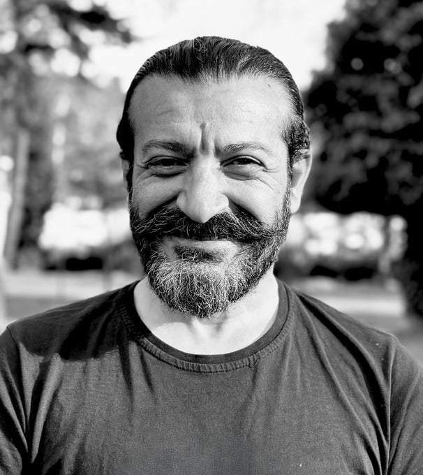 Mehmet Başkak, Tai Ji and Wudang Sword instructor of WDP Turkey, smiling outdoors in black shirt.