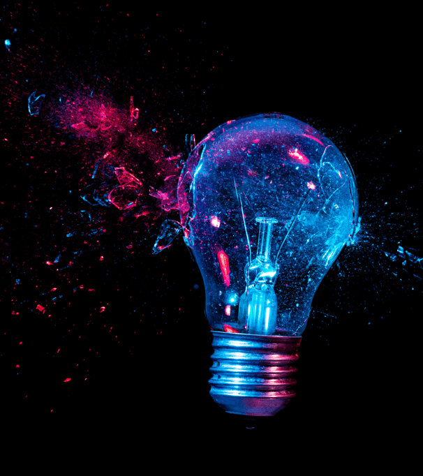 An artistic depiction of a shattered light bulb glowing in vibrant blue and pink hues, set against a