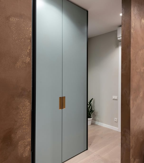 a large closet with a glass door and a potted plant