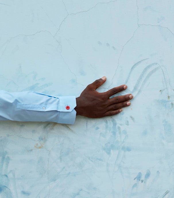 a person's hand holding a red button up