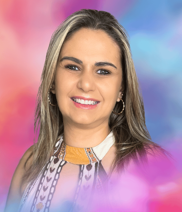Psicóloga Dani Dalcin Benedetti sorrindo com fundo colorido em tons de rosa e azul