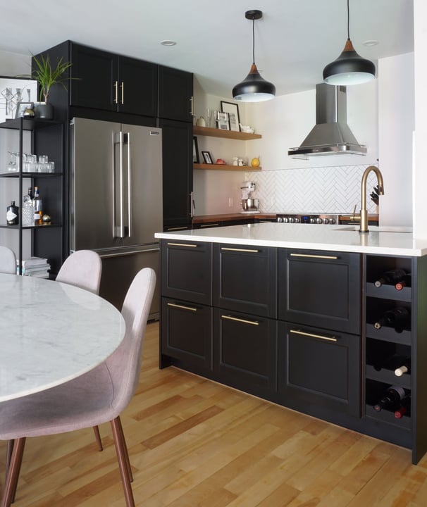 a black kitchen with a marble tulip table and chairs