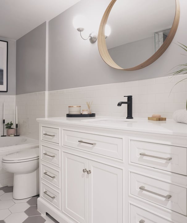 a white and gray bathroom with a large wood mirror