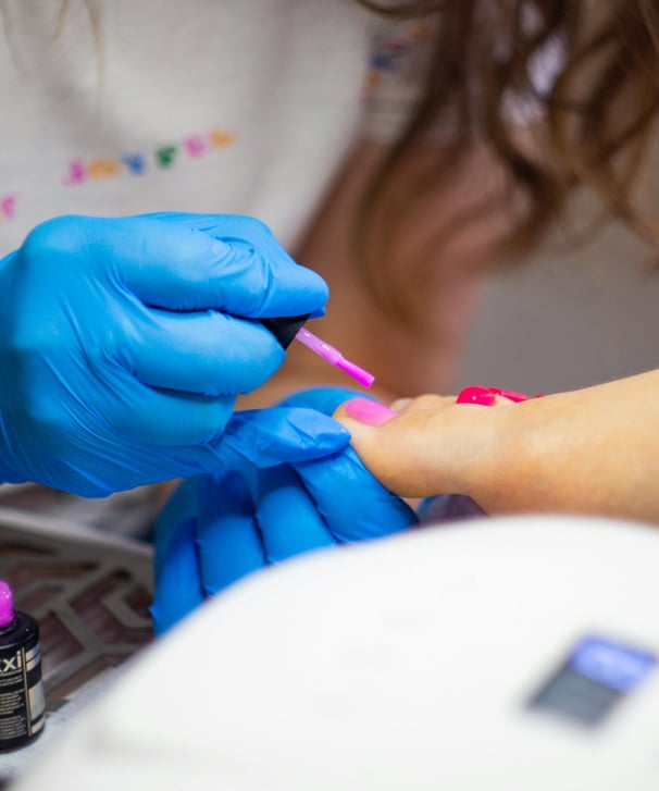applying nail polish on womans feet